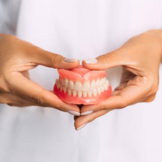 Lady presents viewer with dentures