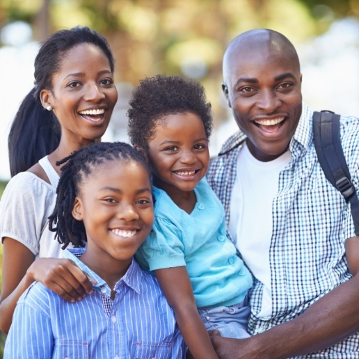 Family of four smiling outdoors