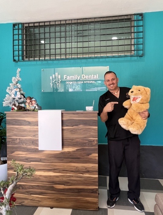 Chicago dentist holding a teddy bear with a set of false teeth