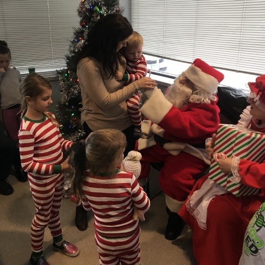 Chicago dentist dressed as Santa Claus giving candy canes to children