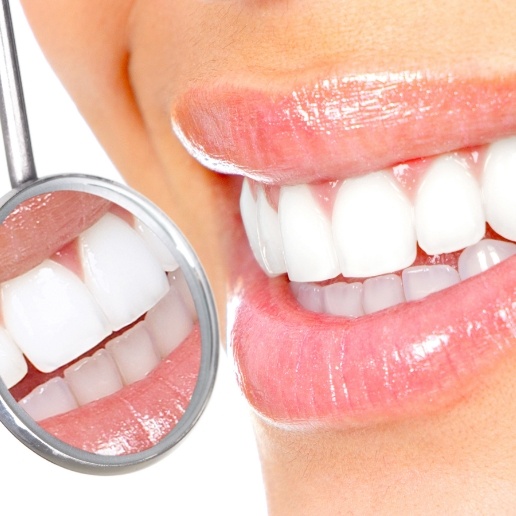 Close up of smile with white teeth next to mirror showing reflection of teeth