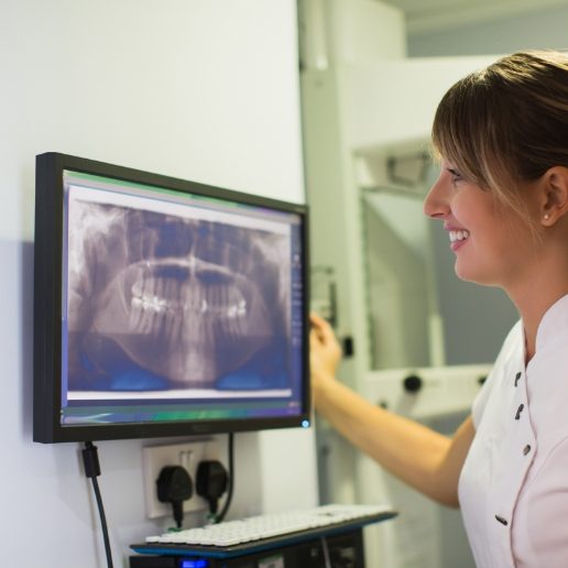 Dental team member looking at dental x rays of a patient