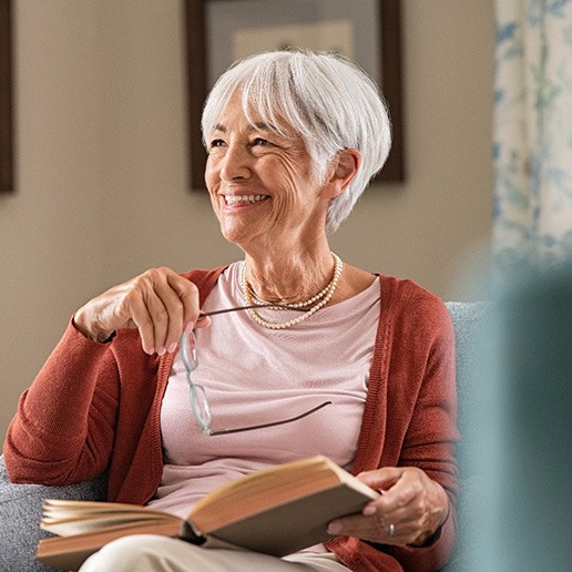 Woman smiling while reading at home