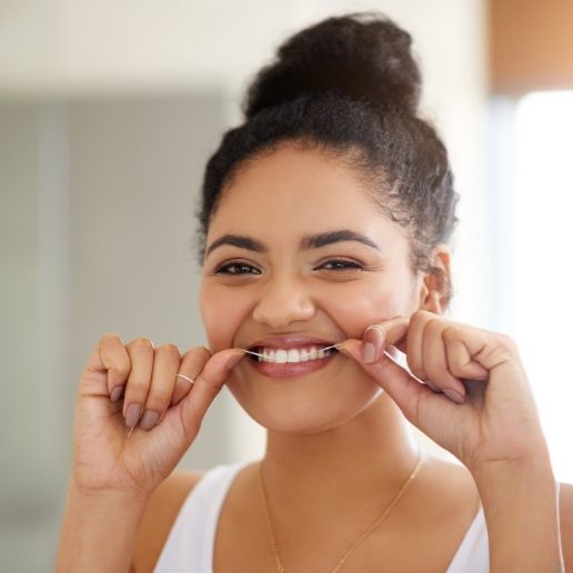 Young woman flossing her teeth