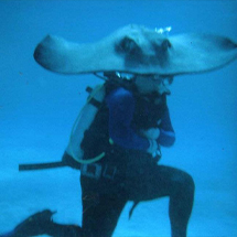Doctor David scuba diving with a sting ray