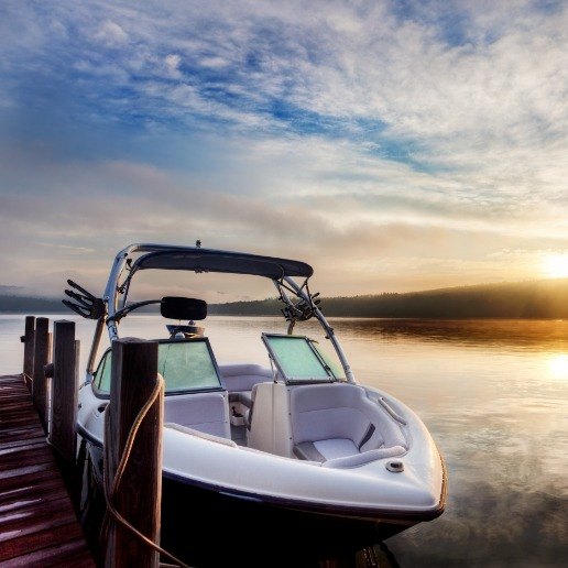 Boat tied to a dock on a lake at sunset