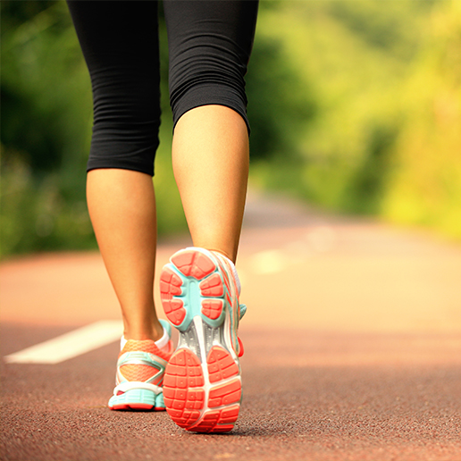 Woman in tennis shoes and black leggings walking on road