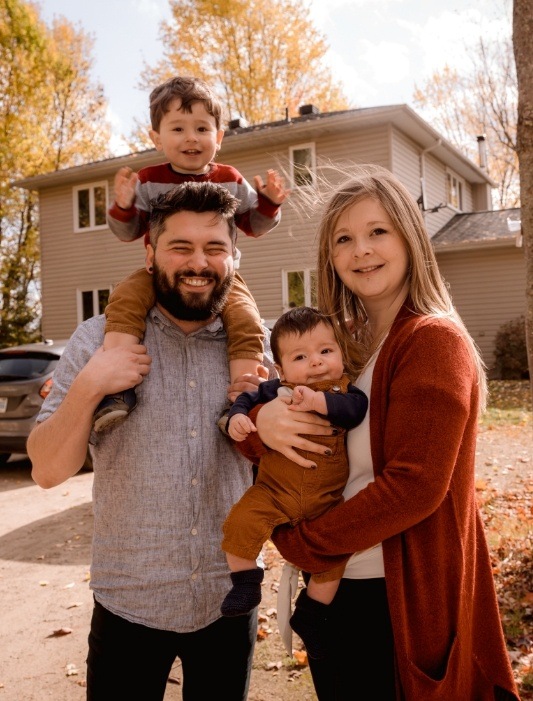 Family of four smiling in front yard after seeing Chicago dentist