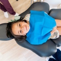 Young girl laying back in dental chair
