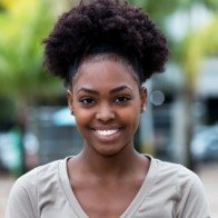 Woman in light gray blouse smiling outdoors