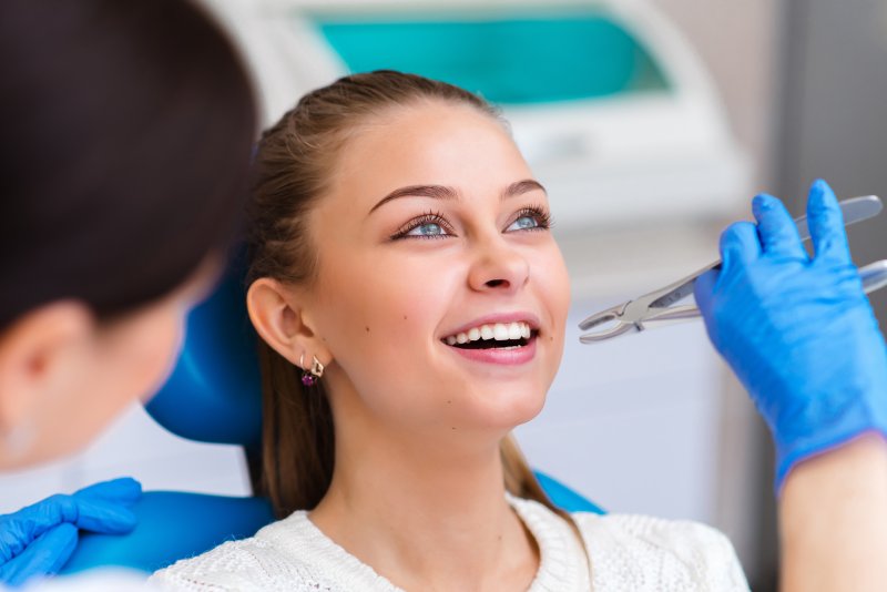 A bright-eyed, smiling woman about to receive a tooth extraction